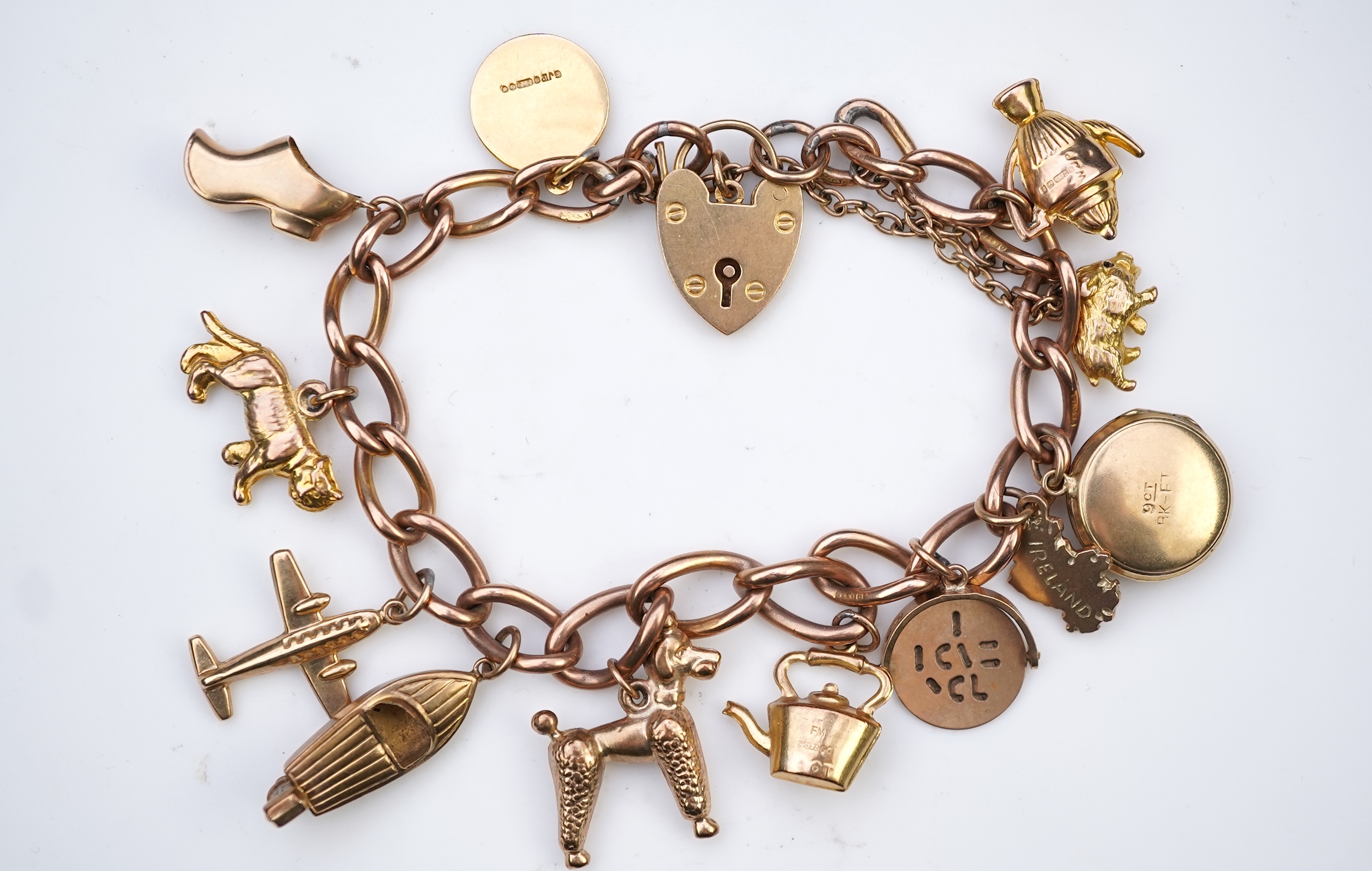 A gold charm bracelet, mid 20th century